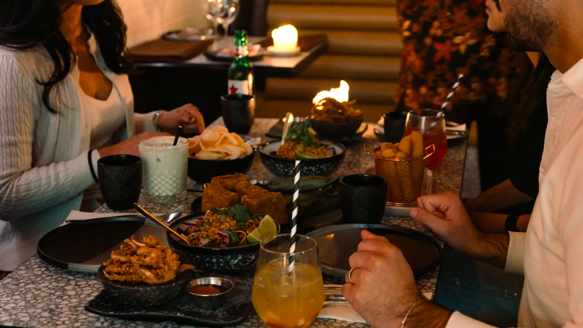 A full table of guests sharing dishes at KKO KKO